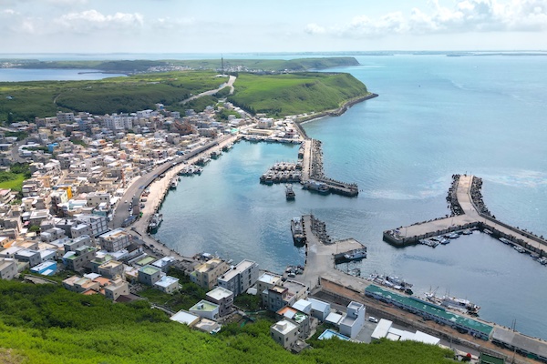 外垵漁港位在澎湖縣西嶼鄉，從三仙塔的位置俯瞰，底下蔚藍大海與弧形漁港美景盡收眼底。